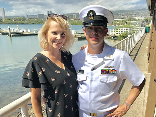 Jackie and her husband stand together smiling